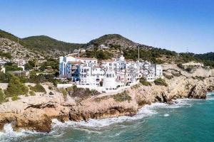 a large white building on a cliff next to the ocean at Sitges Blue - completamente reformado en 2025 in Sitges