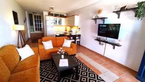 a living room with a couch and a tv at Nicki's House in Agia Anna Naxos