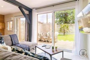 ein Wohnzimmer mit Sofa und Tisch in der Unterkunft Maison charmante à Pontorson avec piscine partagée in Pontorson + 7 Fotos