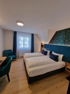 a bedroom with a large bed and a blue wall at Hotel Messmer in Bregenz +37 photos