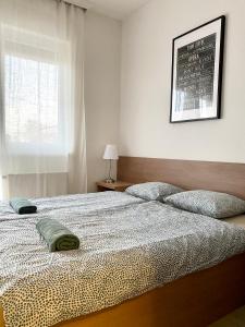 a bedroom with a bed with two pillows on it at Rose Gold Wellness Apartman in Siófok