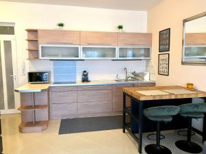 a kitchen with wooden cabinets and a sink and a counter at Rose Gold Wellness Apartman in Siófok