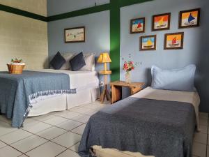 サンルイスにあるPousada Vila do Marのベッドルーム1室(ベッド2台、ランプ付きテーブル付)