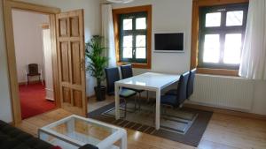 ein Wohnzimmer mit einem weißen Tisch und Stühlen in der Unterkunft Ferienwohnung am Erfurter Dom in Erfurt