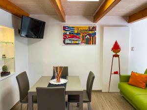 ein Wohnzimmer mit einem Tisch und einem grünen Sofa in der Unterkunft Hot Peppers Apartments in Sant'Agnello