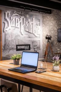 un ordinateur portable assis au-dessus d'une table en bois dans l'établissement Monreale Lifestyle Higienópolis São Paulo, à São Paulo