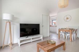 ein Wohnzimmer mit einem großen TV und einem Tisch in der Unterkunft Appartement moderne pour 4 situe a La Baule Escoublac in La Baule