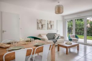 ein Wohnzimmer mit einem Tisch und einem Sofa in der Unterkunft Appartement moderne pour 4 situe a La Baule Escoublac in La Baule