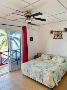 ScubaPortobelo في بورتو بيلو: غرفة نوم بسرير ومروحة سقف