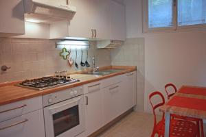a kitchen with white cabinets and a stove top oven at Edera Residence in Trieste