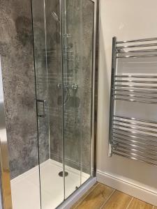 a shower with a glass door in a bathroom at Osprey Lodge 8 with Hot Tub in Newton Stewart