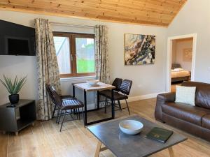 a living room with a couch and a table at Osprey Lodge 8 with Hot Tub in Newton Stewart