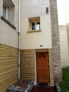 ein Gebäude mit einer braunen Tür und einem Fenster in der Unterkunft Le Verdier in Dieppe