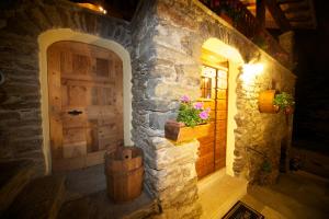 a stone house with a wooden door and a barrel at La Maison Du Seigneur in La Salle