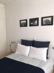 a bedroom with a bed with three pictures on the wall at Charming Suite Private Wc & Balcony in Lisbon