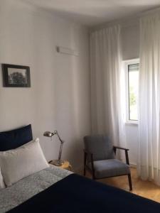 ein Schlafzimmer mit einem Bett, einem Stuhl und einem Fenster in der Unterkunft Charming Suite Private Wc & Balcony in Lissabon