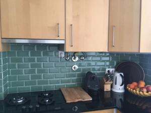 a kitchen with green tile on the wall and a counter at Charming Suite Private Wc & Balcony in Lisbon