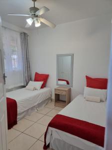 a bedroom with two beds and a ceiling fan at Frere Hill in Durban