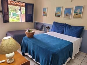 a bedroom with two beds and a table with a chair at Pousada Vila do Mar in São Luís