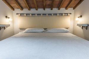 a bedroom with a large bed with two pillows at I Terzi Di Siena - Rooms Only in Siena