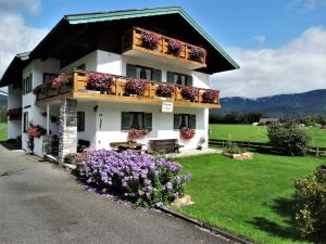 una casa blanca con flores delante en Haus Saurler - Chiemgau Karte en Inzell