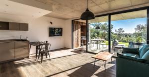 Una sala de estar con un sofá y una mesa y una cocina. en Les Lofts de Sainte-Lucie-de-Porto-Vecchio, en Sainte-Lucie de Porto-Vecchio