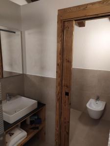 a bathroom with a sink and a toilet and a mirror at Hotel Pilier D'Angle & Wellness in Courmayeur