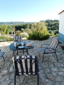 un patio de piedra con mesa y sillas en Baranca Stima en Aldeia de Além
