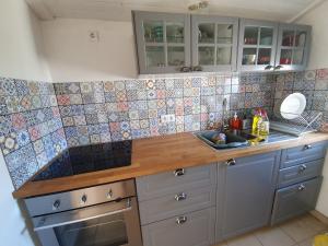 eine Küche mit einem Waschbecken und einer Theke mit Wandfliesen in der Unterkunft Baranca Stima in Aldeia de Além