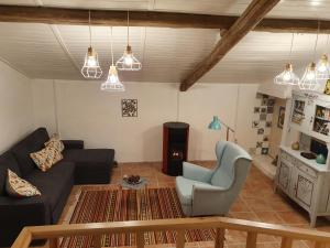 a living room with a couch and a chair at Baranca Stima in Aldeia de Além