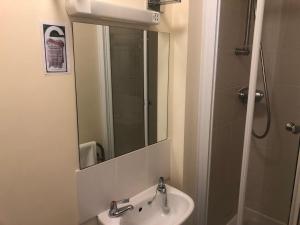 a bathroom with a sink and a mirror at Wayfarer Inn in Instow