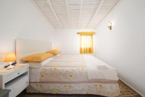 a white bedroom with a bed and a dresser at Casa Morais in Odeceixe