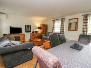 a living room with a couch and a tv at Chestnut Cottage in Aberystwyth