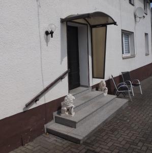 a building with a porch with stairs and a door at Harzhaus in Wienrode