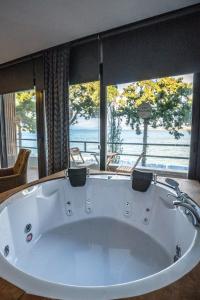 a large white bath tub with a view of the ocean at Sifne Thermal Otel in Cesme