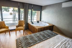 切什梅的住宿－Sifne Thermal Otel，带浴缸、床和椅子的浴室