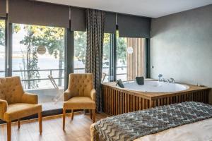 切什梅的住宿－Sifne Thermal Otel，一间卧室配有浴缸、一张床和椅子