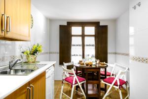 a kitchen with a table and chairs and a kitchen with a window at Sol Badaguas Jaca in Jaca