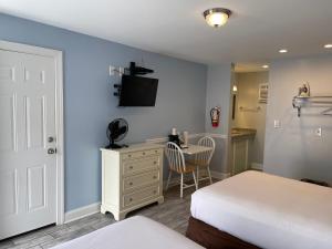 a bedroom with a bed and a desk with a tv at Rio Motel and Suites in Wildwood