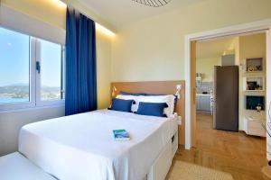a bedroom with a large bed with blue curtains at Kommeno Blue Bay Apt. in Kommeno