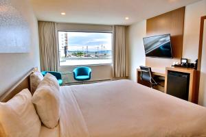 a hotel room with a bed and a window at Hôtel Le Navigateur in Rimouski