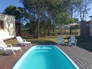 a pool on a deck with chairs and a table at AMORES DEL DIABLO in Punta Del Diablo