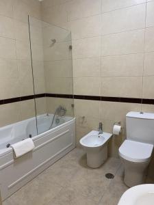 a bathroom with a tub and a toilet and a sink at Estrela da Montanha in Penhas da Saúde