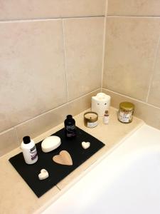 a black tray with hearts and other items on a bathroom counter at Inalong - Quirky property with sea views above an Ale House in The Mumbles