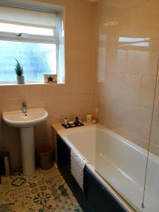 a bathroom with a bath tub and a sink at Inalong - Quirky property with sea views above an Ale House in The Mumbles