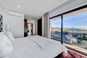 1 dormitorio con 1 cama blanca grande y ventana grande en Sunhouse, en Esposende