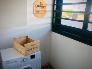 eine Schachtel über einer Waschmaschine in einer Waschküche in der Unterkunft Alegranza, apartamento de 3 habitaciones en Lanzarote in Costa Teguise