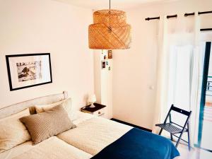 ein Schlafzimmer mit einem Bett, einem Stuhl und einem Kronleuchter in der Unterkunft Alegranza, apartamento de 3 habitaciones en Lanzarote in Costa Teguise + 14 Fotos