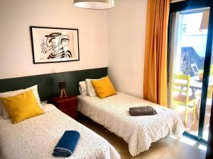ein Zimmer mit zwei Betten und einem Fenster in der Unterkunft Alegranza, apartamento de 3 habitaciones en Lanzarote in Costa Teguise