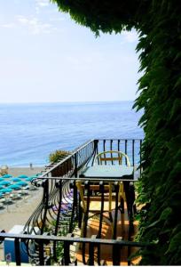 balkon ze stołem i krzesłami na plaży w obiekcie Hotel San Pietro w mieście Letojanni